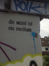 Abb. 3 Graffiti und die Frage der Bedeutung: „die wand ist ein medium“ stencil vs. ROIK tag, Köln, 2009 (Quelle: eigenes Foto)